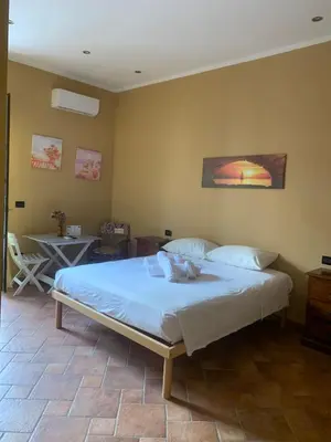 a bedroom with a bed in a room with a table at Casa Alice in Isola delle Femmine