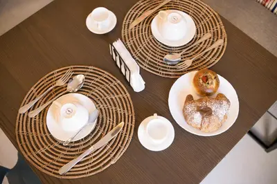 an overhead view of a white tile floor with a table and a chair at Le Tartane B&b Guidaloca in Castellammare del Golfo
