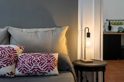 a bed with two pillows and a table with a lamp at Don Mimì Leisure in Palermo