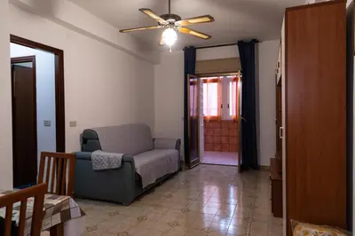 a living room with a chair and a ceiling fan at L'isola Che Non C'è in Isola delle Femmine