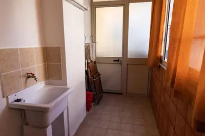 a bathroom with a sink and a window and a door at L'isola Che Non C'è in Isola delle Femmine