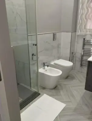 a bathroom with a toilet and a sink and a shower at La casetta dei limoni in Palermo