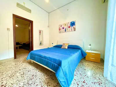 a bedroom with a bed with a blue blanket at NONNA MARI' in Palermo