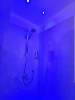 a bathroom with a shower with blue lighting at Confort Home 73 in Palermo