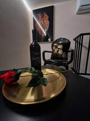 a gold plate with a bottle of wine and a red rose at Confort Home 73 in Palermo
