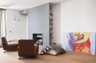 a living room with a chair and a painting at La Cala Terrace by Domusicily in Palermo