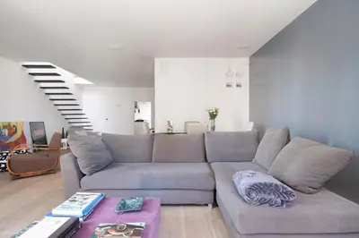 a living room with a couch and a staircase at La Cala Terrace by Domusicily in Palermo