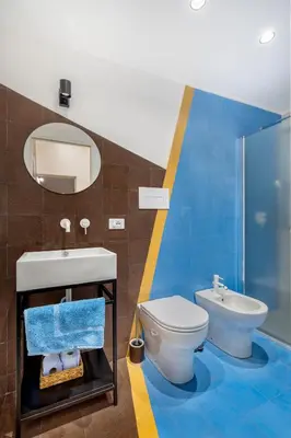 a bathroom with a toilet and a sink and a mirror at CASA FLORIO in Palermo