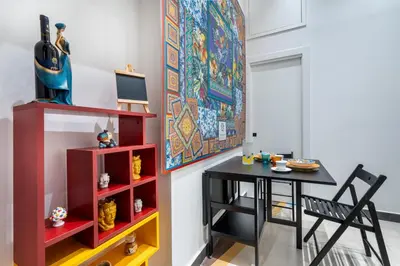 a dining room with a table and a painting on the wall at CASA FLORIO in Palermo