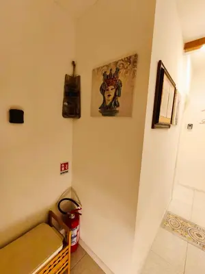 a room with a staircase with a bench and posters on the wall at Sicula Liz & Lulù in Palermo