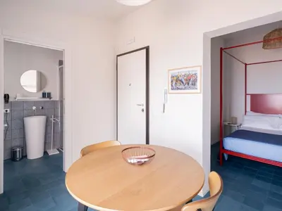 a room with a wooden table and a bed at Piricù Apartments in Castellammare del Golfo