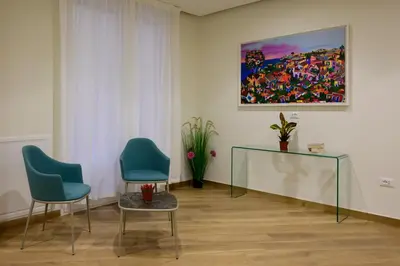 a room with two chairs and a painting on the wall at B&B Maqueda - Room & Suite in Palermo