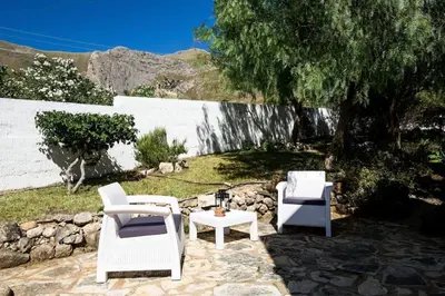 a patio with two white chairs and a table at Villa levante Macari in Macari