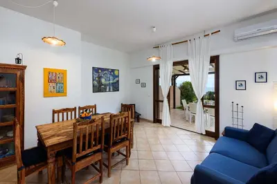 a living room with a table and a blue couch at Villa levante Macari in Macari