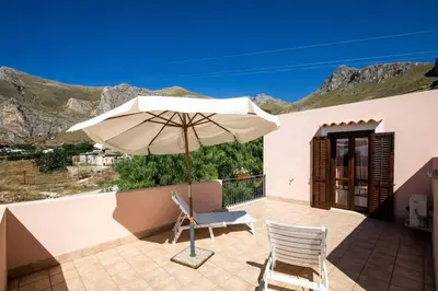 a patio with an umbrella and two chairs at Villa levante Macari in Macari