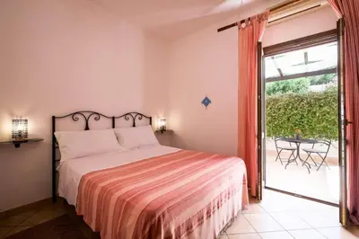 a bedroom with a bed and a large window at Villa Grecale Macari in Macari