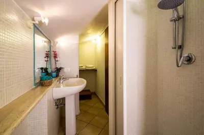 a white bathroom with a sink and a shower at Villa Grecale Macari in Macari