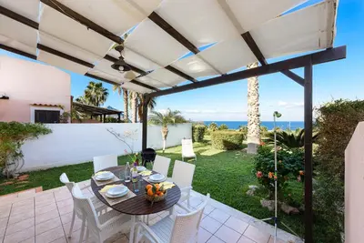 a patio with a table and chairs and the ocean at Villa Grecale Macari in Macari