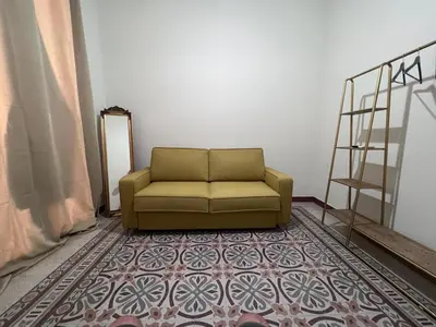 a green couch in a room with a rug at Palazzo Orangea 2 piano in Bagheria