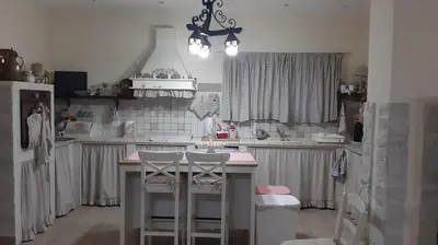 a kitchen with a counter and stools in it at Appartamento uso turistico Villa Barbara in Carini