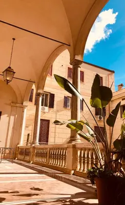 a building with arches and a plant in front of it at Palazzo Ventimiglia Lodge & Suites in Palermo