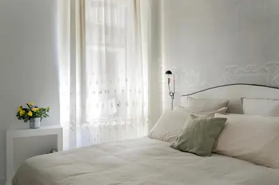 a bedroom with a white bed with a window at Palazzo Ventimiglia Lodge & Suites in Palermo