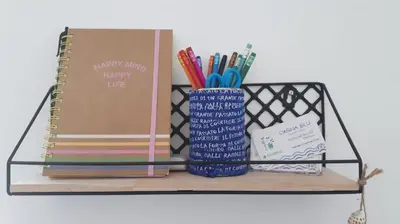 a shelf with a notebook and pens and a book at Casina Blu in Palermo