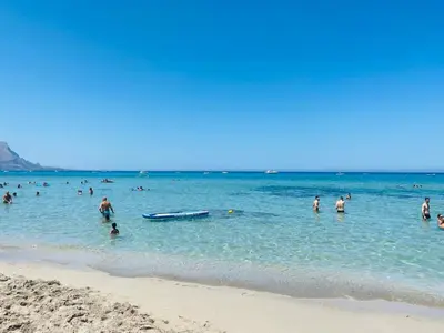 a group of people in the water at the beach at Casa delle Sirene in Isola delle Femmine