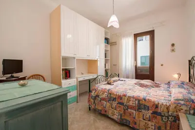 a bedroom with a bed and a desk and a television at A pochi passi dal mare in San Vito lo Capo
