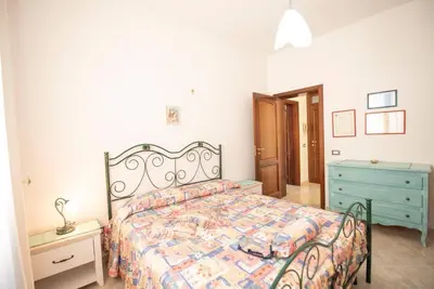 a bedroom with a bed and a blue dresser at A pochi passi dal mare in San Vito lo Capo