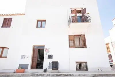 a white building with two chairs in front of it at A pochi passi dal mare in San Vito lo Capo
