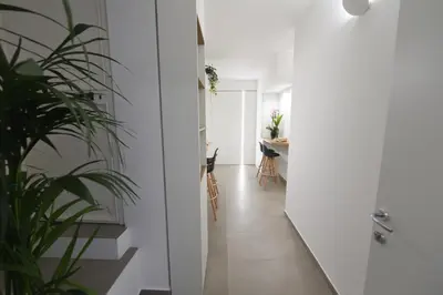 a small kitchen with stools in a room with white walls at Blu in Blu Comfort rooms in Terrasini