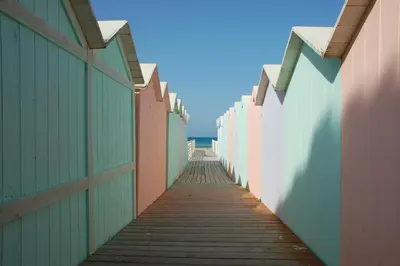 a boardwalk leading down to the beach between buildings at Salsedine Apartment in Palermo