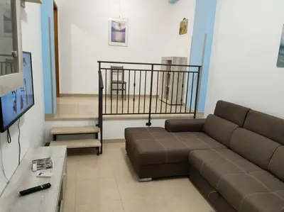 a living room with a couch and a tv at CASA 3T a Isola a 15 min dal centro di Palermo in Isola delle Femmine