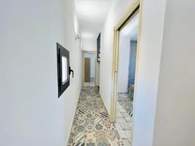 a hallway with a tile floor and a hallway with a mirror at Magaggiari Reef in Cinisi