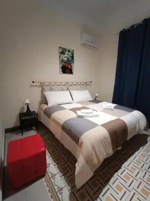 a bedroom with a large bed and a red stool at Room Sixty One in Palermo