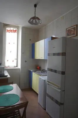 a kitchen with a white refrigerator and a table at Casa di Vale in Palermo