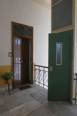 a green door in a building with a plant next to it at Casa di Vale in Palermo