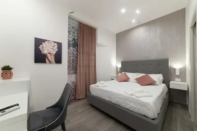 a bedroom with a bed and a chair in it at Blanc Rooms in Palermo