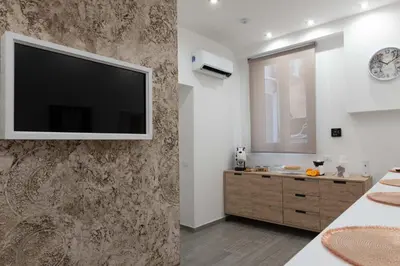 a bathroom with a flat screen tv on a wall at Blanc Rooms in Palermo