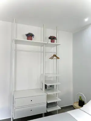 a white bedroom with white shelves and a bed at Attico Belvedere in Palermo