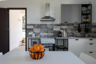 a kitchen with a bowl of oranges on a table at Nice home in Carini