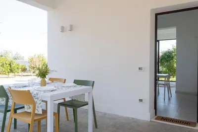 a white dining room with a white table and chairs at Nice home in Carini