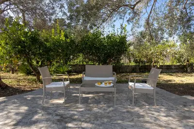 a group of three chairs and a table in a yard at Nice home in Carini