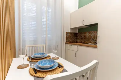 a kitchen with a table with plates and wine glasses at Nena Sweet Home in Palermo