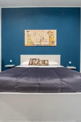 a bedroom with a large bed with a blue wall at Nena Sweet Home in Palermo