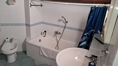 a bathroom with a tub and a sink and a toilet at mansarda beach Mondello in Palermo