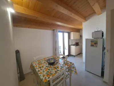 a dining room with a table and a refrigerator at Mamma Rosa Casa Vacanze in Castellammare del Golfo