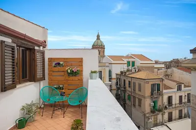 a balcony with two chairs and a view of a city at Suk Ballarò House in Palermo