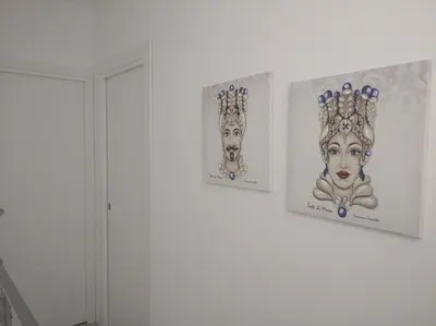 three framed pictures on a wall in a room at Casa vacanze Venere in Balestrate